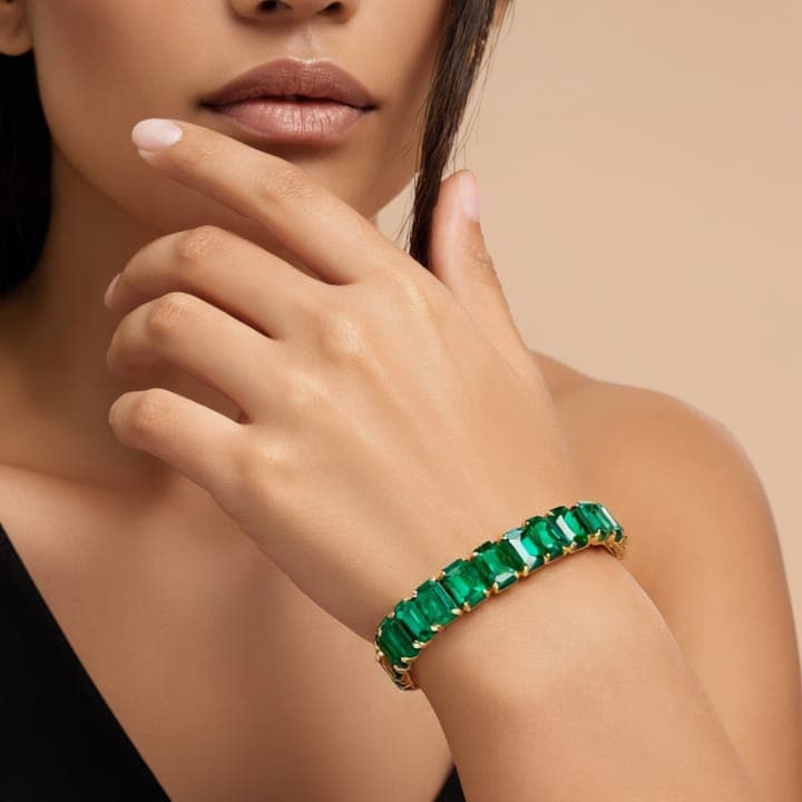 Model wearing an emerald-green crystal tennis bracelet from Ushve